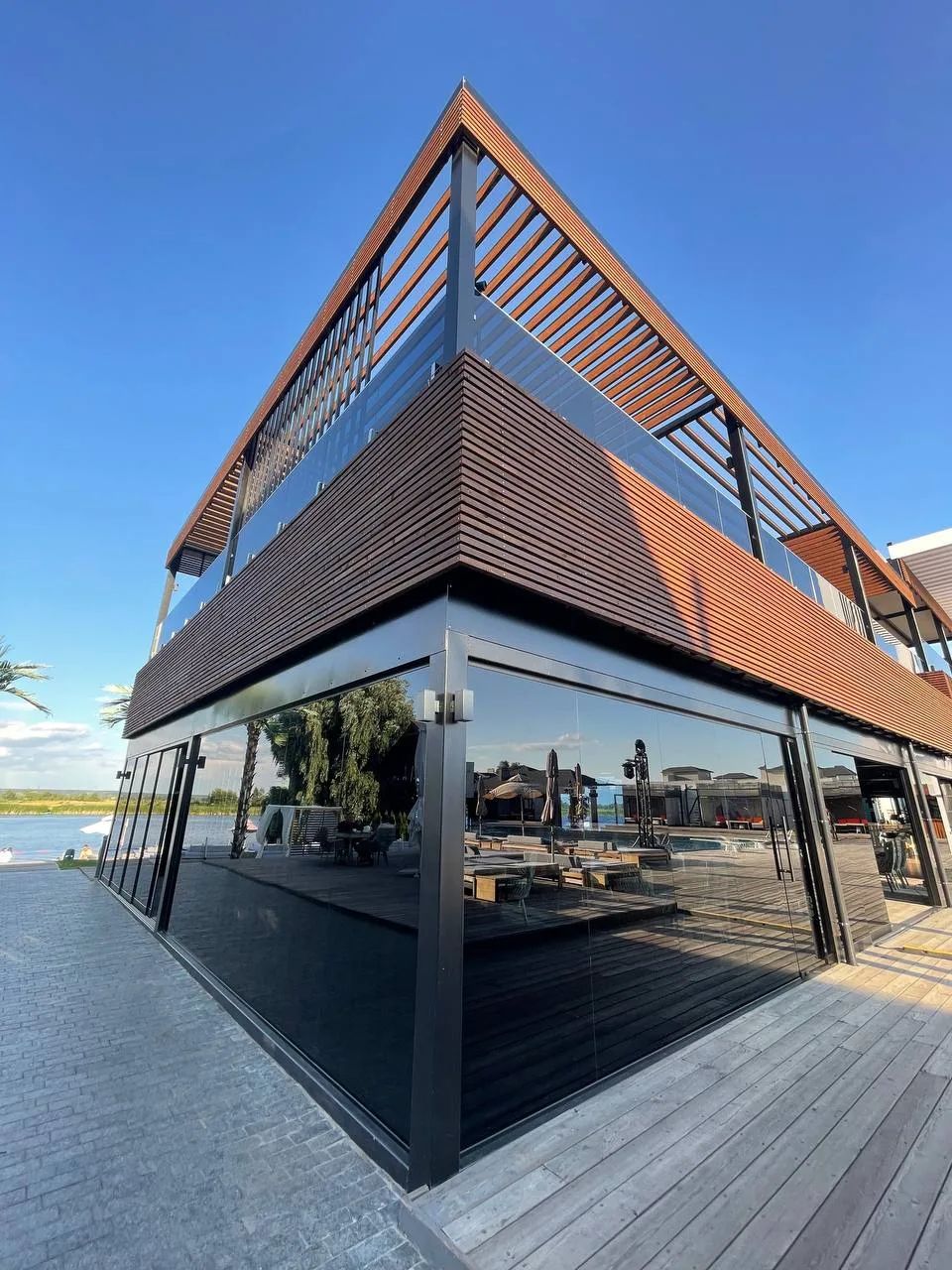 Glazed building with a glass railing on the upper terrace