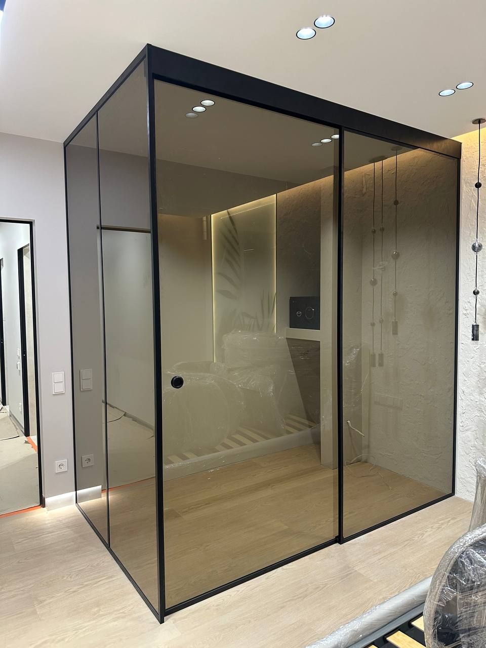 Corner glass wardrobe partition in bronze glass with a black profile
