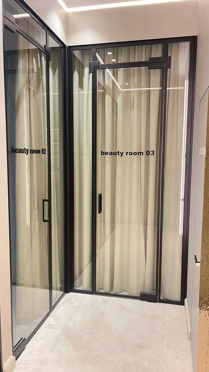 Black-framed glass partitions with doors in a beauty salon